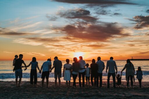 multigeneration family posing on the beach during the sunset