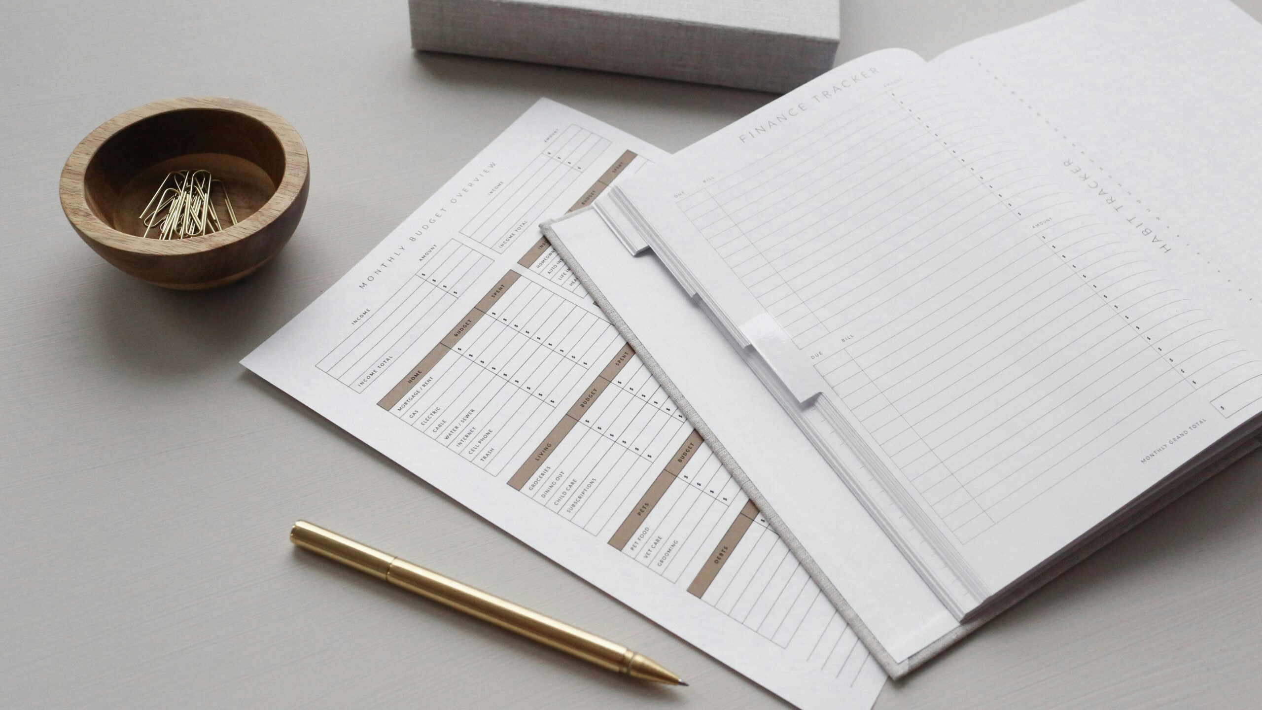 white notebook and golden pen on the table