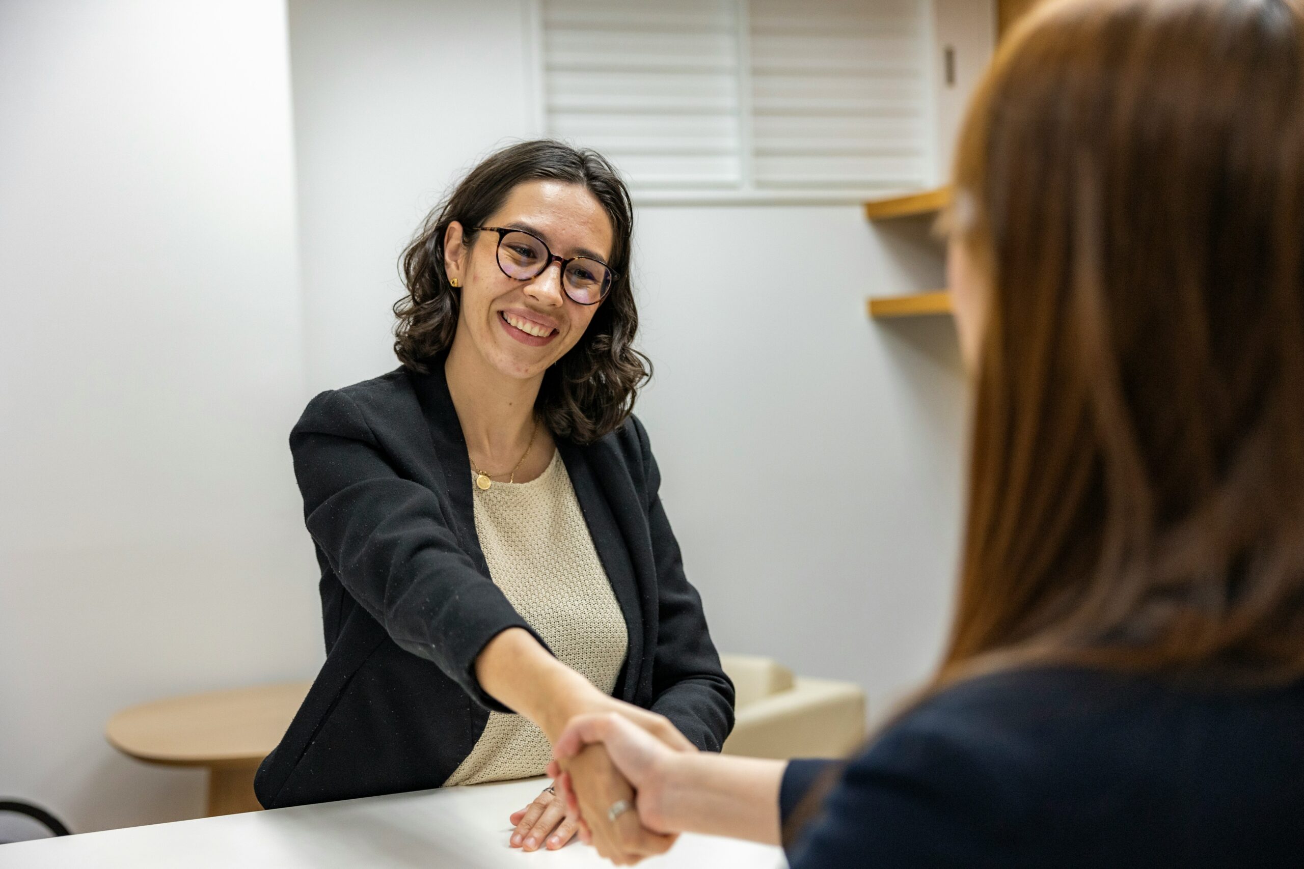 smiling woman giving hand to another woman