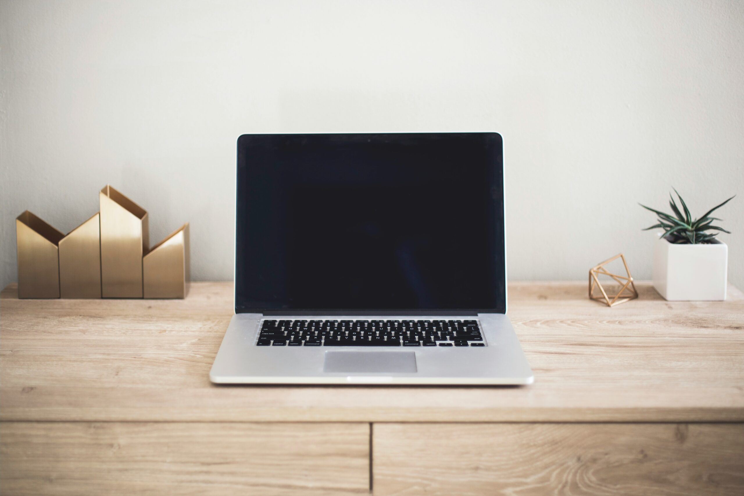 A laptop on a desk in a minimalist workplace.